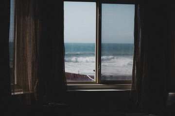 Window Facing Out to a Beach with Waves Crashing in the Distance 