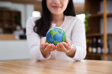 Asian teenager showing earth plasticine on hands, ecology and environment sustainable in global warming crisis during, net zero and carbon neutrality, work and study English to oversea