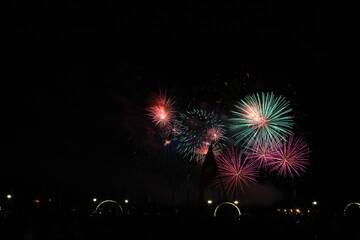 Multicolored fireworks in the dark sky, city day celebration.