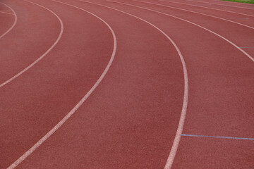 White lines forming lanes of an athletics track made of red rubber