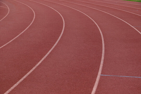 White lines forming lanes of an athletics track made of red rubber