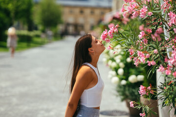 Outdoor portrait of young beautiful lady posing near flowering tree.