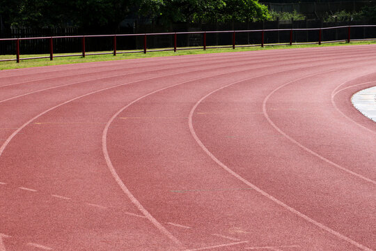 White lines forming lanes of an athletics track made of red rubber