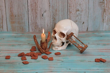 still life in Gothic Halloween style. runes, a skull, a candle, an hourglass with runic signs. The...