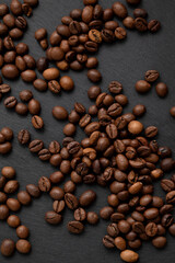 Roasted coffee beans scattered on dark background