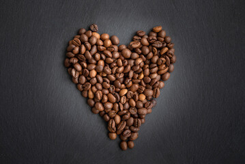 Heart made by roasted coffee beans on dark background