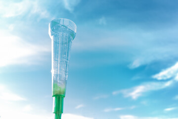 the manual measurement rain gauge is empty due to drought and in the background the blue sky with light clouds