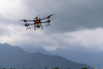 Fototapeta na wymiar Agriculture drone farming fly to spray fertilizer on the rice fields