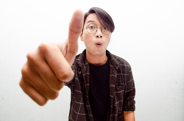 Young Asian man smiling happily and giving thumbs up as compliment