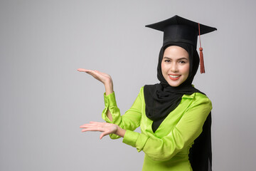 Young smiling muslim woman with hijab wearing graduation hat, education and university concept.