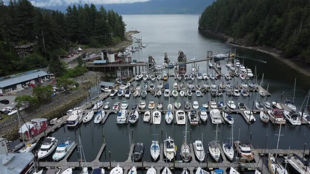 Drone shot of the boats in Bowen island harbor with the sea, cliff and greenery