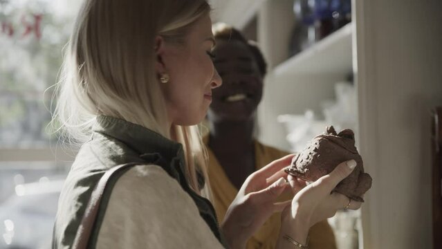 Close up of women shopping in retail store for frog statue / Pleasant Grove, Utah, United States