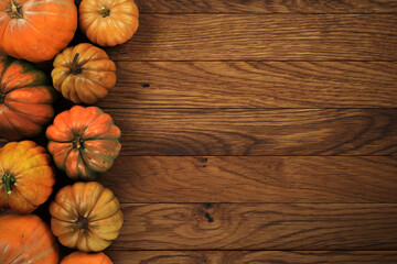 Top view of orange pumpkins on a wood planks.