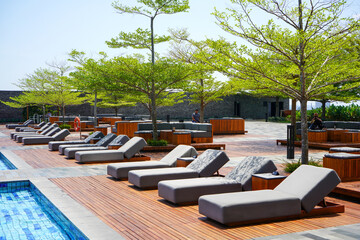 Sleeping chairs and lounge chairs by the pool and beach for lying down and relaxing rest. Foam chairs, pillow, towel, bolster. 