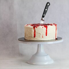 designer chef decorating white red bloody horror crime cake for halloween party