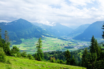 Panoramic view of countryside, green alpine meadows and mountains