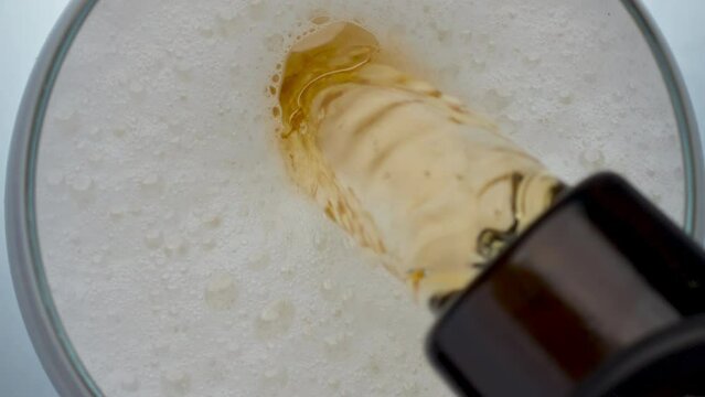 Refreshing ipa filling goblet closeup. Malt liquid pouring glass slow motion