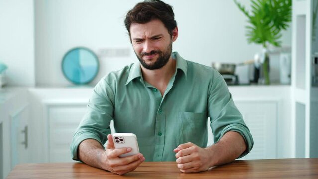 Concerned worried annoyed angry millennial Hispanic young man holding smartphone, feeling outraged by low wifi internet signal, bad connection, application crash. Software problems on cell phone