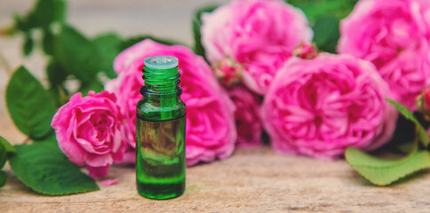 Rose essential oil in a bottle. Selective focus.