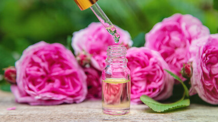 Rose essential oil in a bottle. Selective focus.