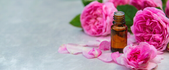 Rose essential oil in a bottle. Selective focus.