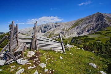 Fototapeta na wymiar The remains of a mountain hut with peaks Schrocken and Pyhrner Kampl at Totes Gebirge mountains in the Alps, Austria