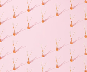 Aromatic wooden sticks in perfume. Pastel pink bacground. Pattern with copy space.