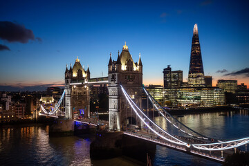 Historic Bridge over River Thames and Cityscape Skyline during dramatic sunset. Tower Bridge in City of London, United Kingdom. Travel Destination.