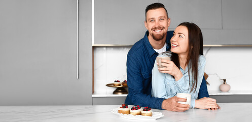 Happy young couple drinking tea with cakes at home