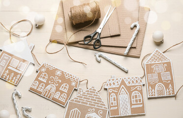Handmade cardboard houses as Christmas decor on white wooden background