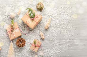Fototapeta na wymiar Christmas gifts with snow on grey wooden background with space for text