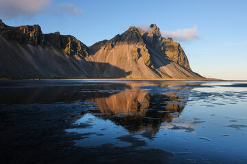 Fototapeta na wymiar View of Vestrahorn mountain at stokksnes cape reflecting in the water on the beach. Wonderful natural landscape of Iceland. Shot in autumn