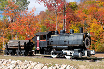 Colorful fall foliage and historic steam-powered Porter Locomotive coupled to freight car. Used for...