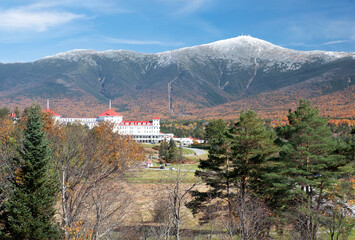 Colorful autumn scene at Bretton Woods, New Hampshire. Blue sky with dusting of snow on summit of...