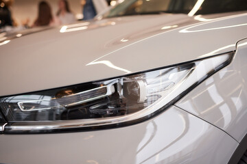 Obraz na płótnie Canvas Headlights and hood of sport white car with silver stars.