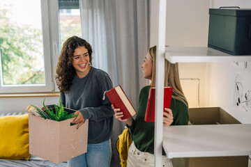 female college student move in dorm. they are talking in the room