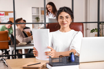 Fototapeta na wymiar Young businesswoman with documents working at table in office