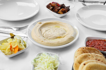 Plate with tasty hummus on table in restaurant, closeup
