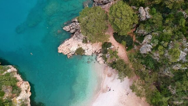 The girl swims in the blue water. Panoramic view of Pirate bay or Korsan Koyu near Karaoz, Antalya. Summer and Holiday background.
