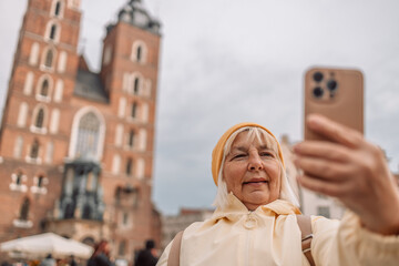 Portrait of wonderful senior woman tourist expressing energy in good day making selfie photo in...