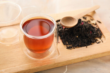 Fototapeta na wymiar Wooden board with cup of black tea on grunge background, closeup