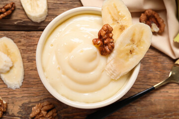 Ramekin of delicious vanilla pudding on wooden background, closeup