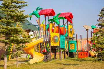 Bright playground in the park. Playground with slides and swings for children.