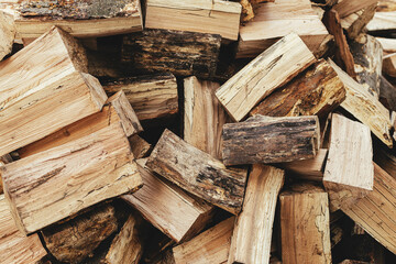 Firewood. Stack of firewood close up, wooden background. Chopped wood for fireplace heating, alternative to gas and electricity. Lumber pattern, log