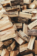 Firewood. Stack of firewood close up, wooden background. Chopped wood for fireplace heating, alternative to gas and electricity. Lumber pattern, log