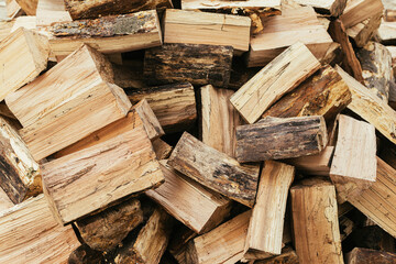 Firewood. Stack of firewood close up, wooden background. Chopped wood for fireplace heating, alternative to gas and electricity. Lumber pattern, log