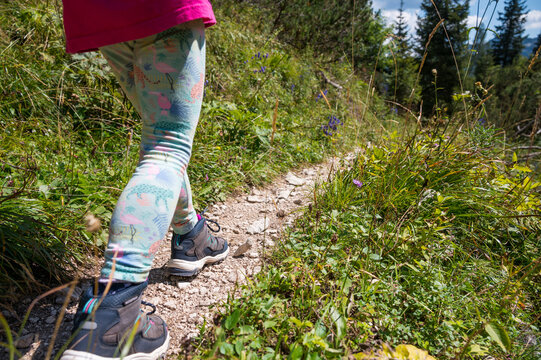 Detail of a young child walking along forest path.