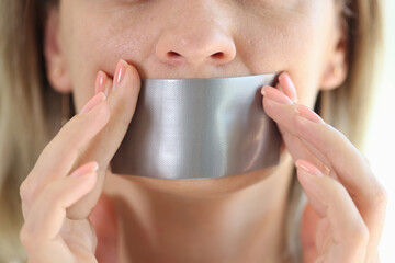 Young woman with duct tape sealed on mouth