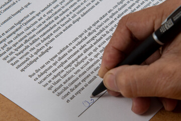 printed document signature showing a hand and ballpoint pen.