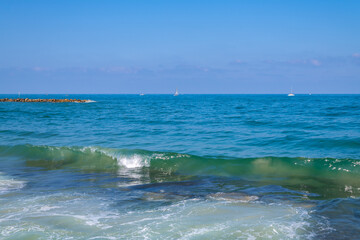 Overview of beach and wave breakers, jetties on the coastline of the Mediterranean Sea in Tel Aviv, Israel.

